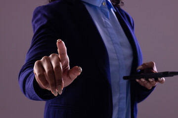 Biracial businesswoman using smartphone with copy space on grey background