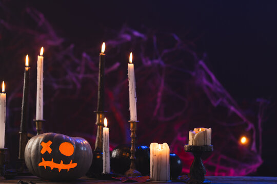 Fototapeta Pumpkins and candles with copy space on purple background