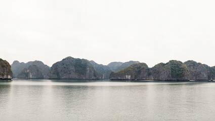 Scenic view on rock islands with fishing boats in Ha Long Bay. Cat Ba, Vietnam.