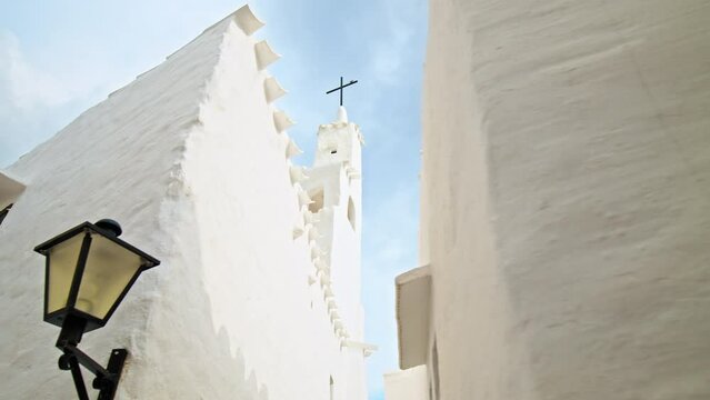 Binibeca Vell - a coastal village with narrow streets and whitewashed houses. White church tower on a summer sunny day in Menorca, Balearic Islands, Spain in 4k ProRes