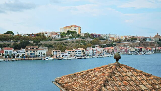 Beautiful view of Mahon with a Clay Tiles Roofing in the foreground in Menorca. A view of the capital of Menorca with seashore houses and boats on the Balearic Islands, Spain