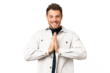 Brazilian man over isolated chroma key background keeps palm together. Person asks for something