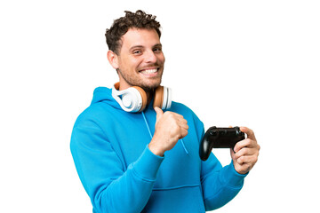 Brazilian man playing with a video game controller over isolated chroma key background proud and...