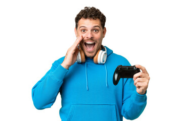 Brazilian man playing with a video game controller over isolated chroma key background with...