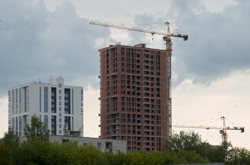 Fototapeta na wymiar Construction of new residential buildings: construction site with crane and construction equipment