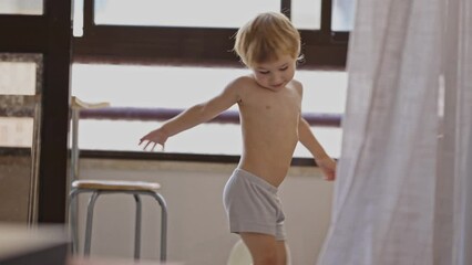 Little boy in underpants having fun in the kitchen