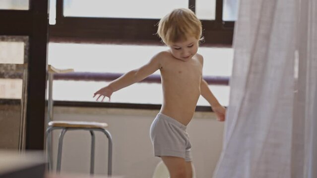 Little boy in underpants having fun in the kitchen