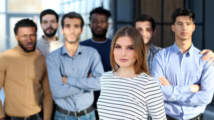 Obraz premium Successful millennial business woman stands at the forefront of a multiethnic team