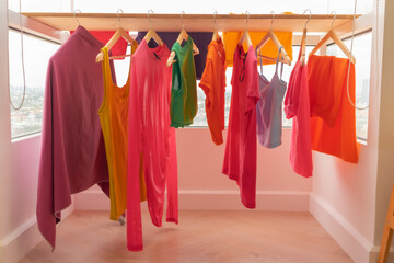Colorful clothes hanging on the balcony dry in sun at apartment.