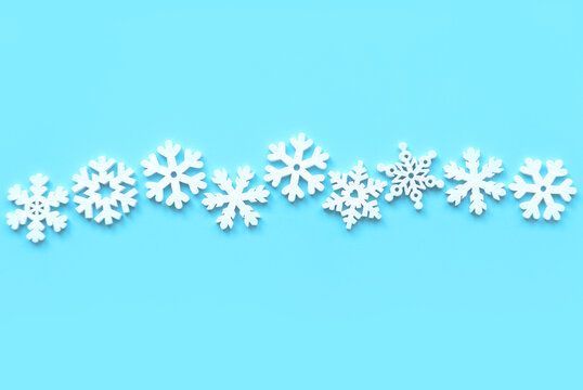 Various wooden snowflakes shape on blue background.