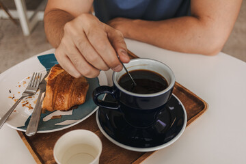 Set of croissant and americano hot coffee at cafe.
