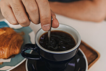  Set of croissant and americano hot coffee at cafe.
