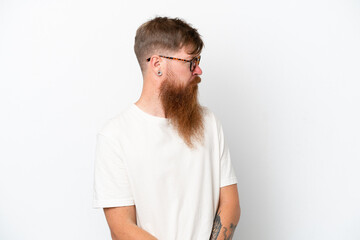 Fototapeta premium Redhead man with long beard isolated on white background keeping the arms crossed