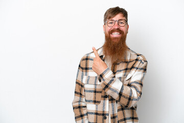 Redhead man with long beard isolated on white background pointing to the side to present a product