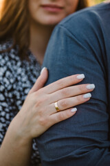 Woman hugs man. Photo married couple hugging, husband and wife. Closeup. Summer. Portrait of romantic male and female in love on nature. Husband and wife in sunlight. Engagement ring.