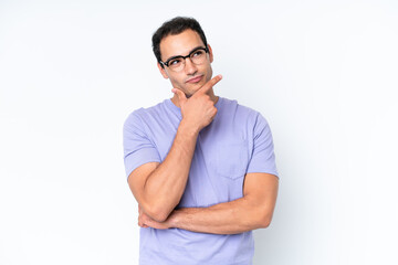 Fototapeta premium Young caucasian man isolated on white background thinking an idea while looking up