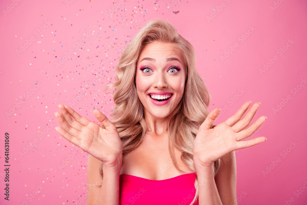 Poster Portrait of astonished cheerful person raise opened arms palms beaming smile flying confetti isolated on pink color background