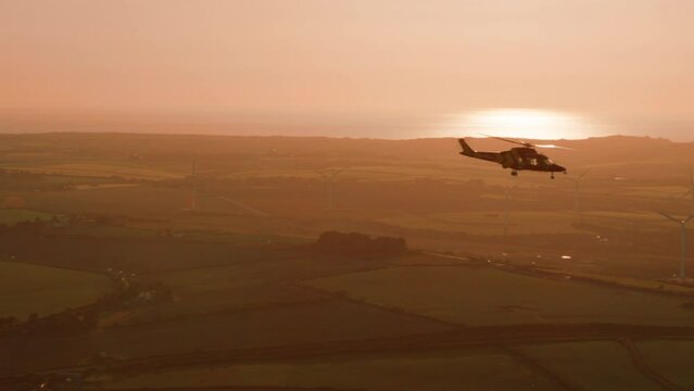 Helicopter flying at sunset over Cornwall