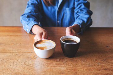 Closeup image of a woman holding and serving two cups of hot coffee