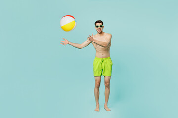 Full body young sexy fun man wear green shorts swimsuit relax near hotel pool hold in hand toss up...