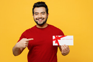 Cheerful young smiling happy Indian man he wears red t-shirt casual clothes hold point index finger...