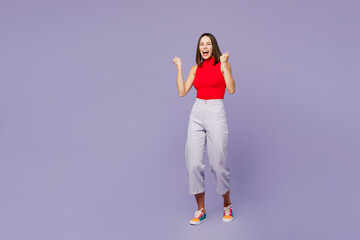 Fototapeta na wymiar Full body overjoyed excited happy exultant young woman she wears red tank shirt casual clothes doing winner gesture isolated on plain pastel light purple background studio portrait. Lifestyle concept.