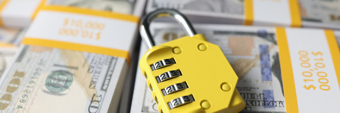 Yellow code lock on top of pile of cash