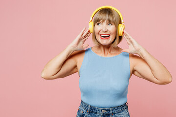 Elderly blonde woman 50s years old she wears blue undershirt casual clothes listen to music on...