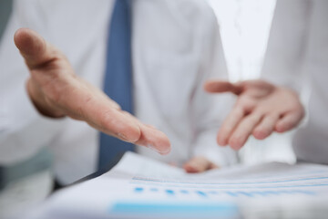 Close-up of business people in smart discussing something while looking at the graphs and charts