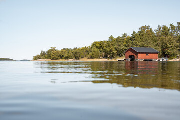 Fototapeta na wymiar Panorama einer Küstenlinie mit rotem Bootshaus, Erholung in Schweden, Ausflug in Skandinavien