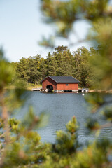 Obraz premium rotes Bootshaus an der Küste von Schweden, Urlaub in Skandinavien