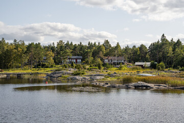 Naklejka premium schwedische Häuser im Wald an der Schwedischen Küste auf einer Insel, idyllisches Wohnen in der Natur