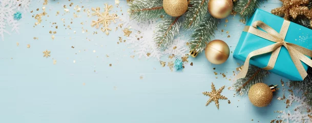 Fotobehang christmas card with a gift wrapped in turquoise paper with golden Christmas decorations and fir branches with confetti on a wooden background top view, legal AI © PETR BABKIN