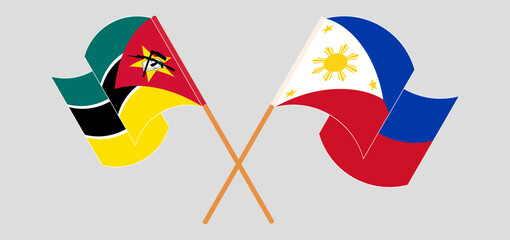 Crossed and waving flags of Mozambique and the Philippines