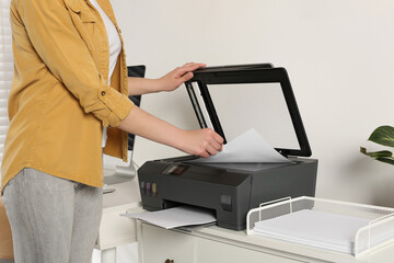 Woman using modern printer at home, closeup