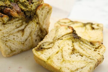 Freshly baked pesto bread on white table, closeup