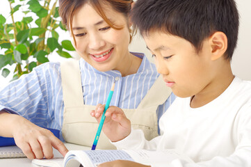勉強を頑張る男の子と教える母親
