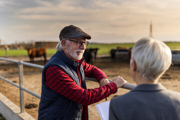Farmer and business woman on cow farm