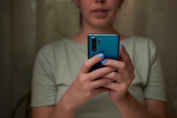 Woman is using smartphone, writing a message, browsing social networks.