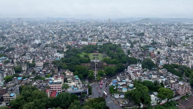 Aerial footage of Shaniwar Wada, a fortification in Pune city, India with busy roads and building roof tops in monsoon season. Pune city drone shot. Indian city aerial with historic and modern archite