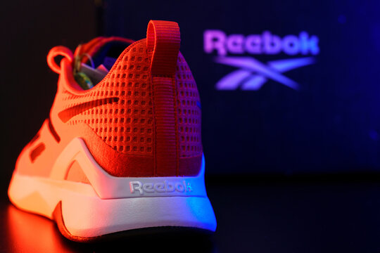 Tyumen, Russia-August 03, 2023: Stylish red Reebok footwear for sports. Multicolored light. Selective focus. Copy space
