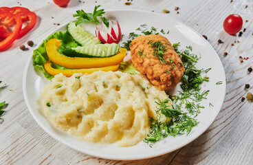 Fried chicken steak or schnitzel with mashed potatoes on black stone table.