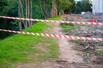 Red and white barrier tape protects a dangerous place