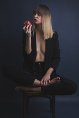 woman sitting on a chair. Boudoir photography. Concept photography. A woman and a red apple
