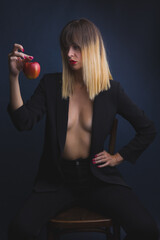 woman sitting on a chair. Boudoir photography. Concept photography. A woman and a red apple