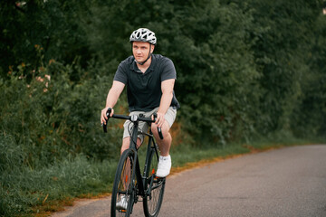 Young Male Cyclist Embracing an Active Lifestyle. A front-view image of a cyclist riding his gravel bike in the countryside