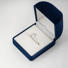 Beautiful shiny ring with diamond in velvet box isolated on white background.