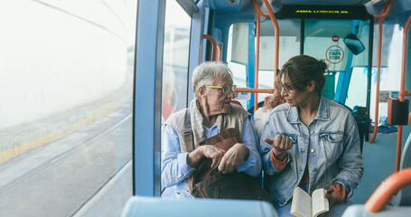 Senior man and mature woman talking together while traveling with tram transportation - Soft focus on man face - obrazy, fototapety, plakaty