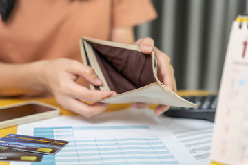 Stressed and headache woman with large bills or invoices no money to pay to expenses and credit card debt. shortage, Financial problem, bankruptcy, mortgage, loan, bankrupt, poor, empty wallet .