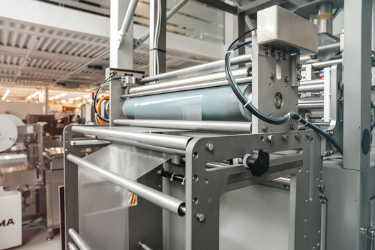 Processing of Packaging equipment thermoformer on food vacuum packaging sealing machine in industrial factory. Packing food in production line. Vacuum machine